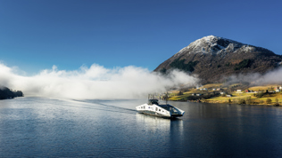 Foto: Svein Egil Økland Ferje på en fjord med fjell i bakgrunnen